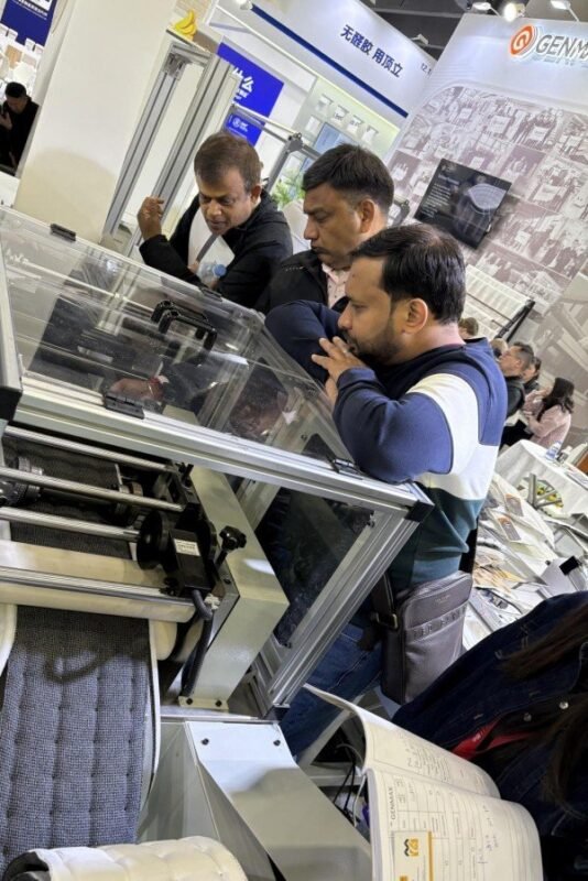 Customer inspecting the control panel interface of GENMAX’s quilting machine at the CIFF exhibition.