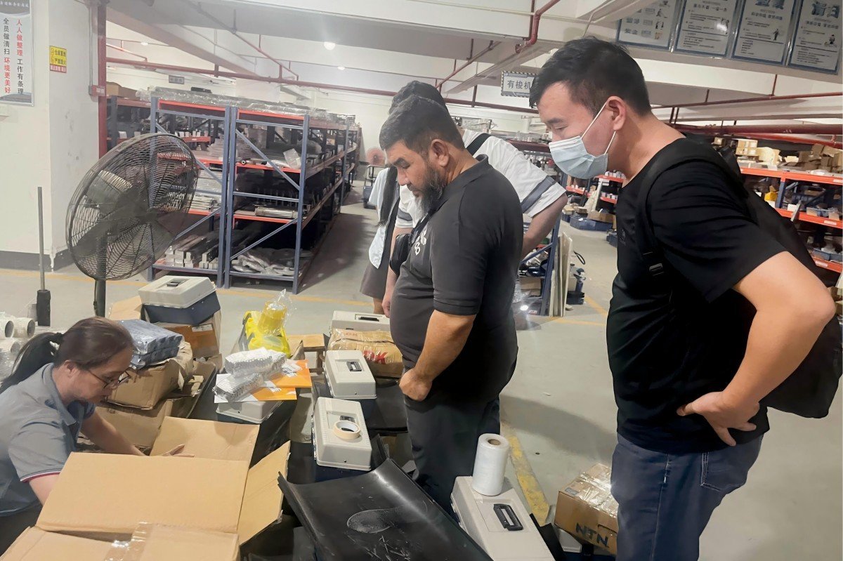 Saudi Arabian textile industry representatives carefully examining quality control accessories and components for industrial quilting machinery during their factory visit.